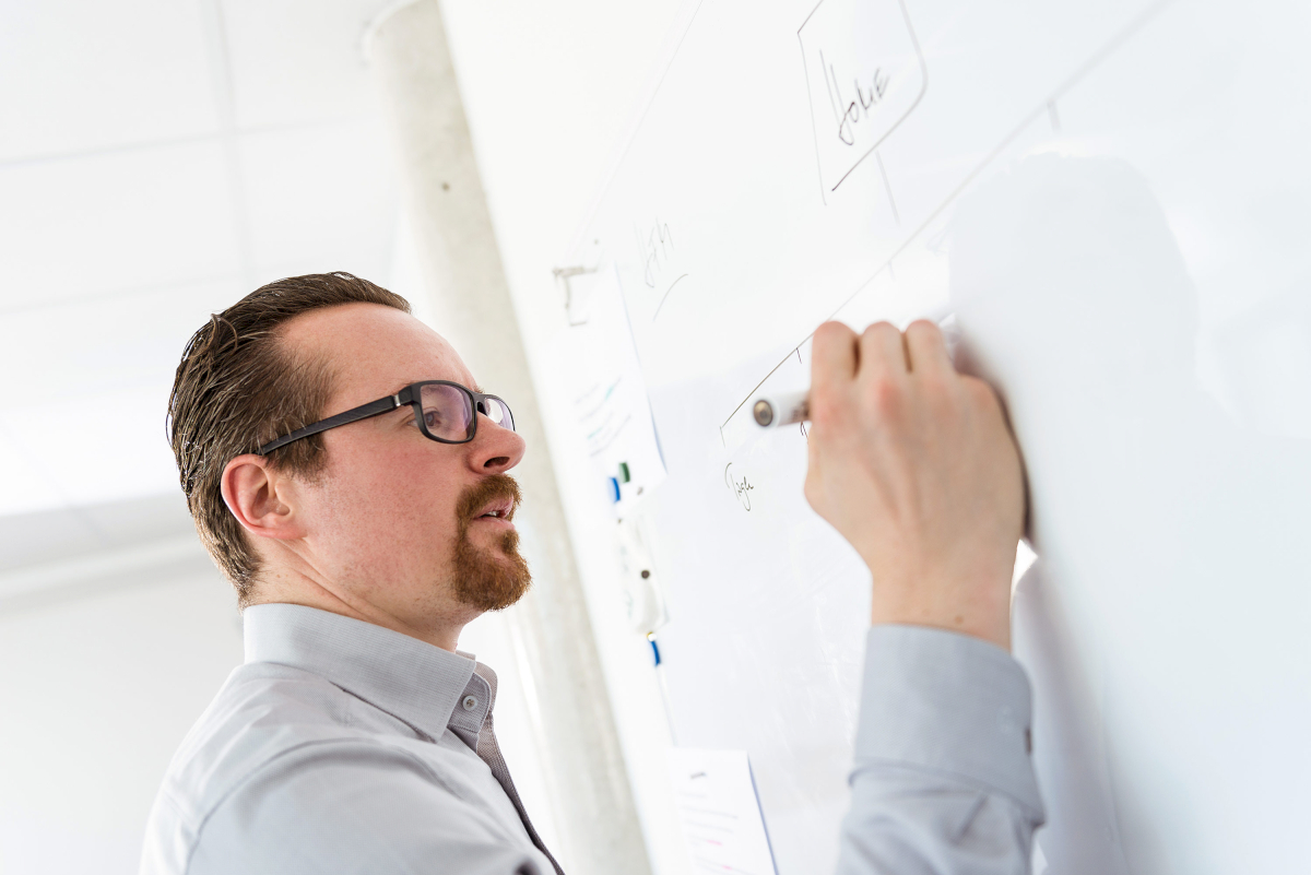 typneun Designagentur Gründer Stefan Manhart erarbeitet ein Konzept an einer Magnettafel