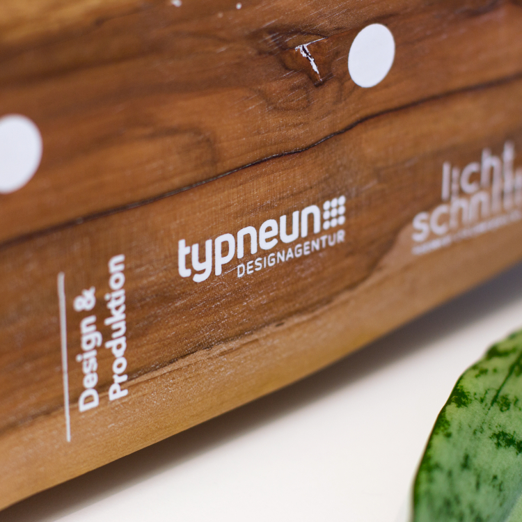 Gravur des typneun Logo Designs auf einer Holztafel