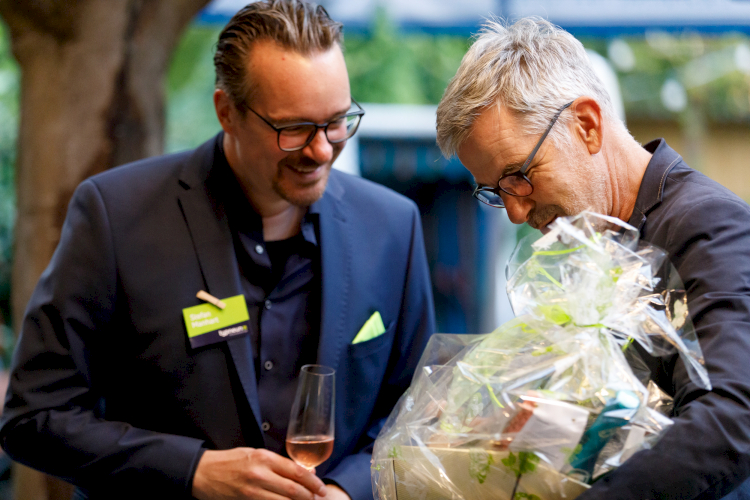 Typograf Stefan Manhart nimmt Gastgeschenke auf dem typneun Jubiläum entgegen